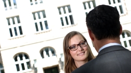 Eine Studentin im Gespräch mit einem Unternehmer  - im Hintergrund das Hauptgebäude der Fachhochschule Köln (Bild: FH Köln/Thilo Schmülgen)