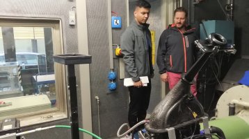 Zwei Personen vor einer Maschine im Labor.