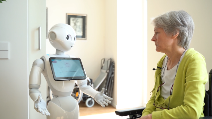Eine Dame spricht mit Pepper dem Roboter