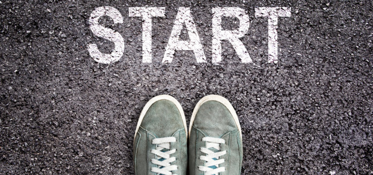 Sneaker shoes and the word START written on asphalt ground (Image: Start_AdobeStock_Delphotostock_255575819)